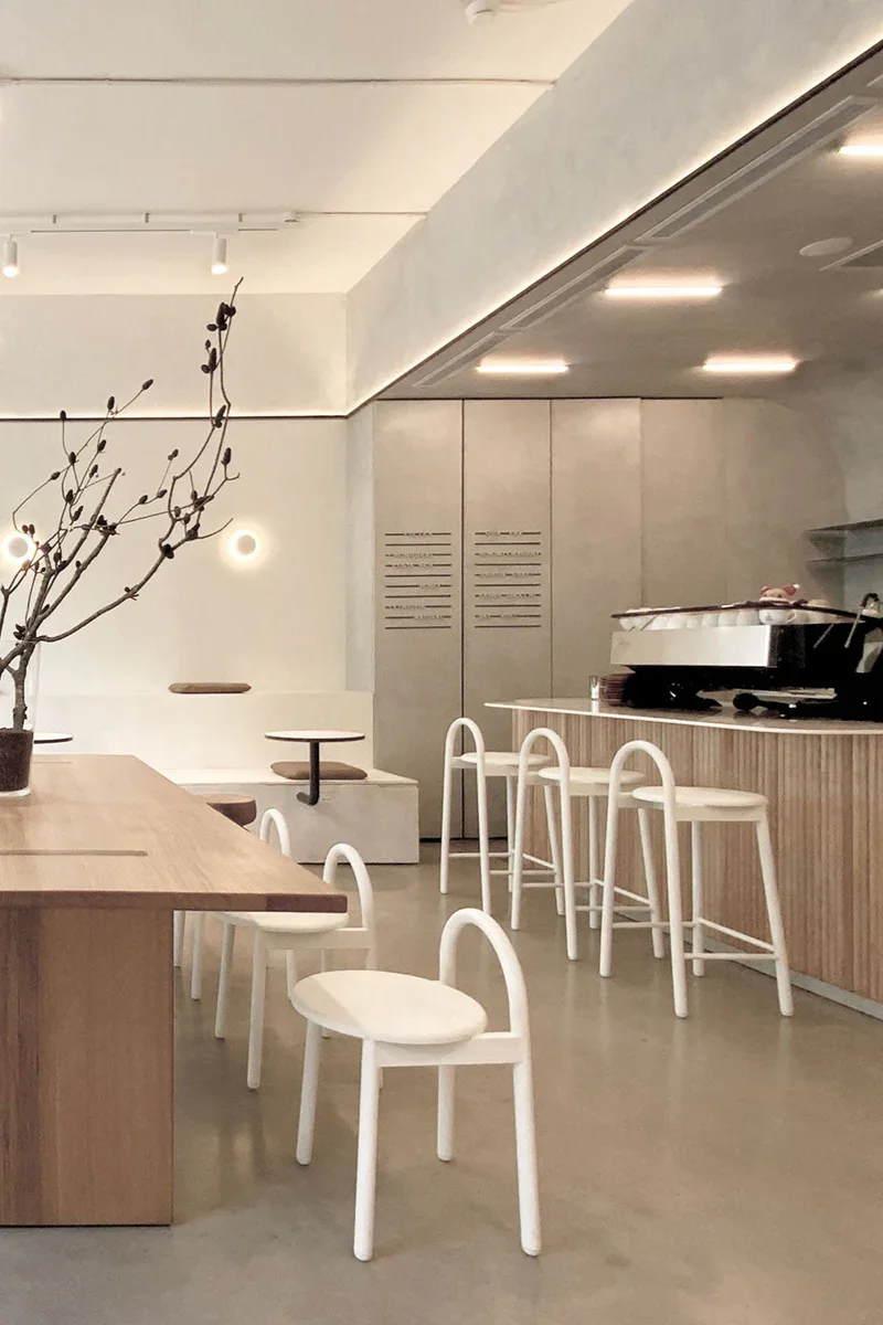 A minimalist café interior furnished with light, sculptural Belmares Studio seating